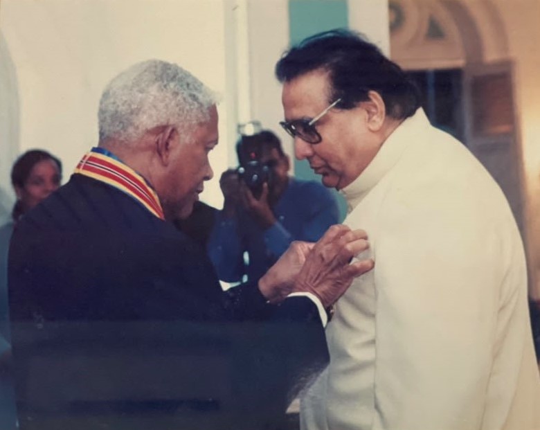 President Arthur N. R. Robinson pinning the Humming Bird Medal (Gold) on Prof. Hari Shanker Adesh